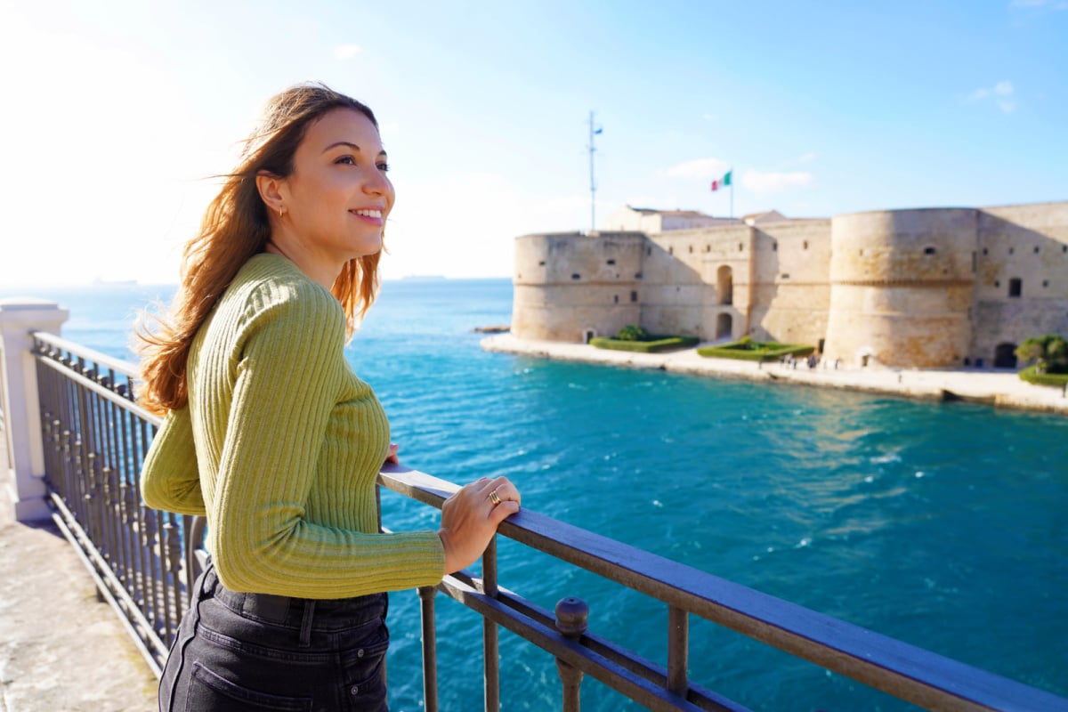 Woman overlooking Castello Aragonese, Taranto, Italy